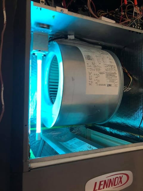 Interior of a Lennox HVAC unit showing the motor and fan assembly illuminated by blue light